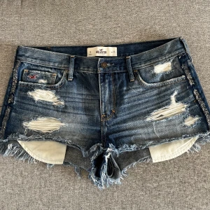 Lågmidjade jeansshorts - Säljer dessa snygga lågmidjade blå jeansshorts från hollister! Köpta här på plick, säljer då de tyvärr inte passade. Liten defekt på sidan då några paljetter lossnat!