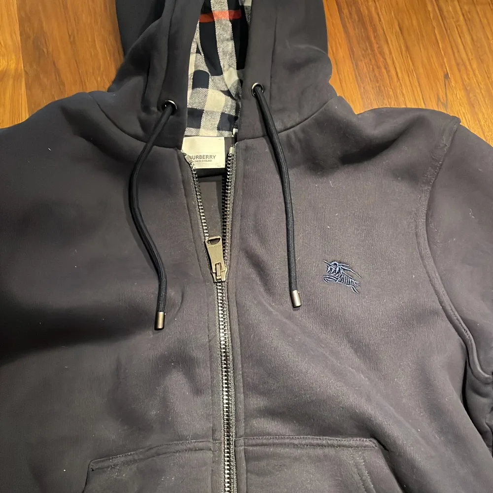 Burberry zip hoodie som har blivit för kort så det är dax att sälja , den är i storlek M och inga fläckar , märken , hål etc. Jag säljer den för ett bra pris för jag vill bli av med den snabbt . Tröjor & Koftor.