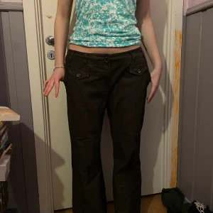 Bootcut jeans  - Brun/svarta jeans som är lite pösiga och väldigt snygga. Är utsvängda vid benen och har väldigt snygga fickor 