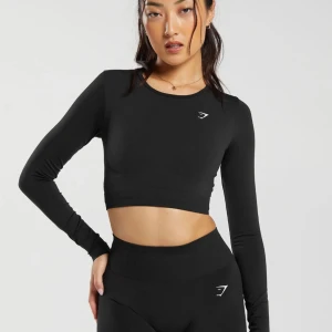 Gymshark Långärmad Crop Top - Gymshark long sleeve crop top. Sparsamt använd och formar kroppen jätte fint! Super bra material och långa ärmar som man kan stoppa in tummen i 🤩 Storlek XS. Nypris 350kr