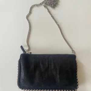 Zara väska - Jag säljer den här väskan då jag inte andvänder den längre. Den är i bra skick då jag har tagit hand om den.  Perfekt om man vill ha en mindre väska till sommaren.  OBS!! Se bild 2, lite slit på nitarna,  inget märkvärdigt 