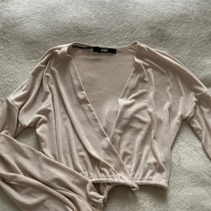 Blus från Bikbok - Långärmad blus som är cropped. Är av ett litet tyngre material så att toppen lägger sig efter ärmarnas och axlarnas form. Är i storlek L men sitter jätte fint på S och M då det är snörning vid midjan. 