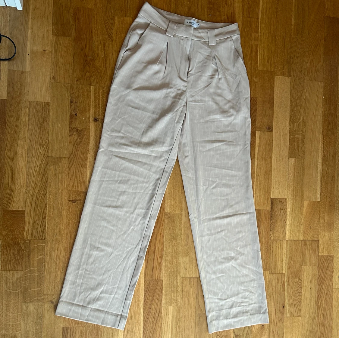 Beiga kostymbyxor med vita ränder från NA-KD