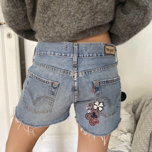 Levis shorts med detalj - Blåa jeansshorts från Levis med cool detalj på rumpan. Går att vika upp om man vill ha kortare! Lågmidjade