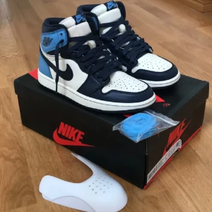 jordan 1 obsidian - Jordan 1 obsidian med box samt extra snören. Använda i 1 år men är nästan som nya. skick 8/10 då de är lite slitna på insidan hälen.  Priset går att duskuteras.