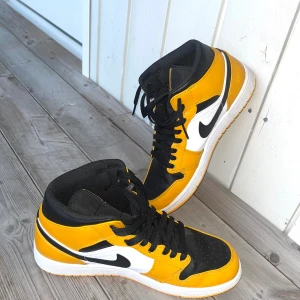 Air Jordan 1 Mid Taxi  - Snygga Nike Air Jordan 1 Mid i gul och svart färg. Perfekt för vardagligt bruk eller för att ge din outfit en sportig touch. Air Jordan 1 Mid Taxi  US 9.5 EUR 43 UK 8.5