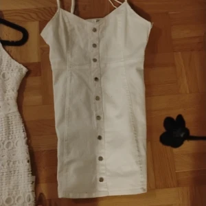 Klänningar storlek 40 - En virkad klänning i spets en jeansklänning med knappar en randig klänning med snörning i midjan, alla är nya men oanvända