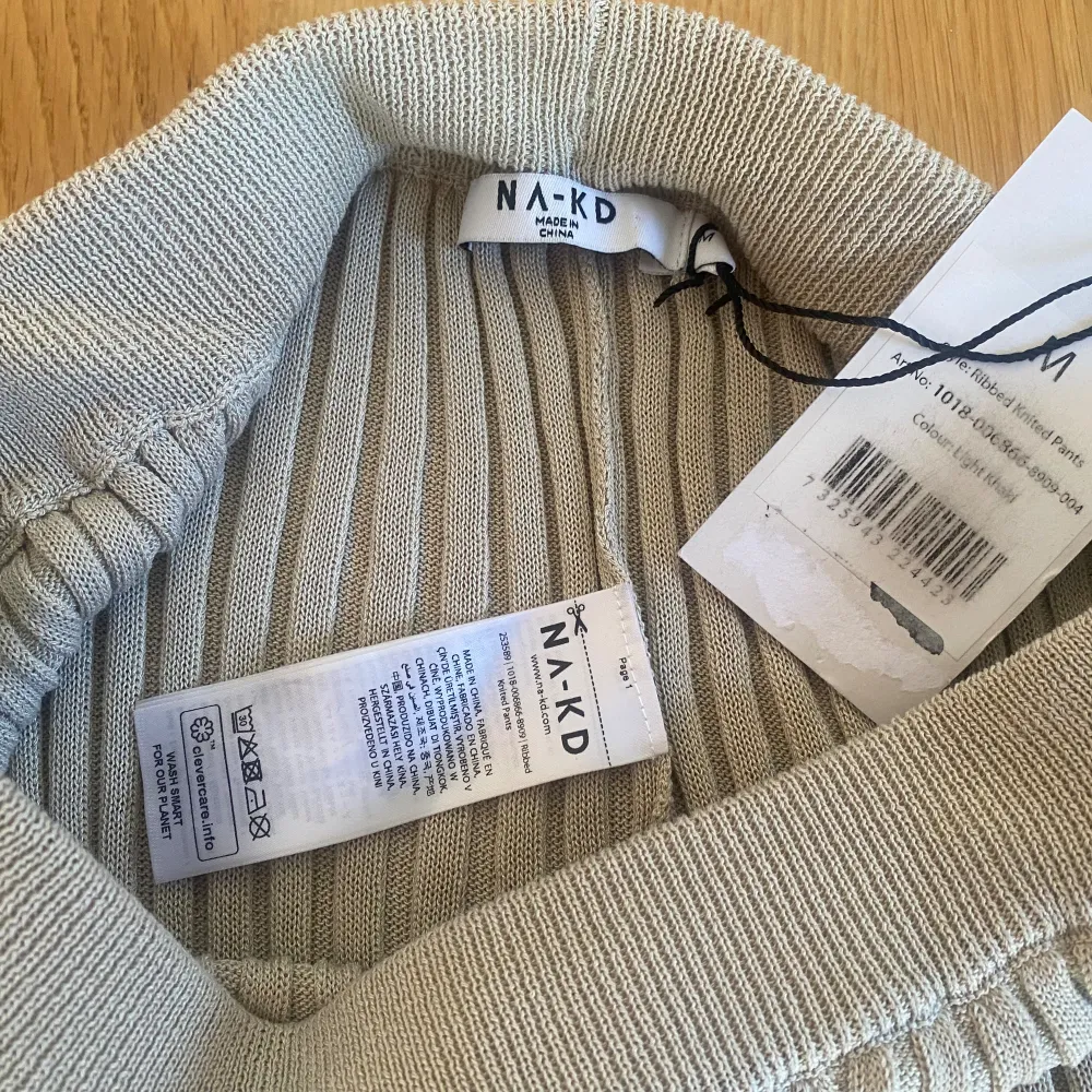 Nya beiga stickade ribbade byxor från NA-KD strl M. Modell: Ribbed knitted pants Den sista bilderna är lånade från NA-KDs hemsida Nya, med prislappen kvar Mått Midjan: ca 33 cm Längd från grenen och ner: ca 86 cm 89% viskos och 11% polyamid . Farkut & Housut.