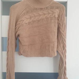 Brun stickad tröja - En brun stickad tröja som är använde någon gång.