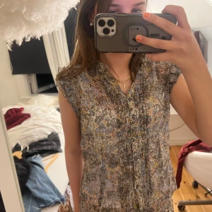 Sommarblus! - Jätte fin sommarblus, blommig i olika neutrala färger! Lite as snygg volang på axeln! Nyskick!