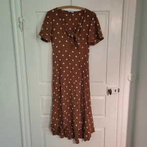 Brun och vitprickig klänning - Fint skick endast använd 1 gång. Storlek 36, passar både S och Xs