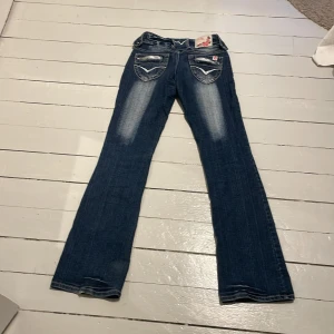 utsvänga jeans  - Jättecoola jeans från new age men liknar crazy age. Lågmidjade och utsvänga. Midjemått: 34 cm med stretch och innerben: 79cm. Dragkedja trasig!!!! 