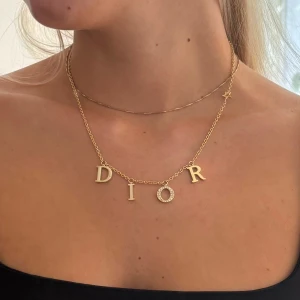 Dior halsbanf - Dior halsband (ej äkta) i guldigt rostfritt stål. En Sten har lossnat längst ner på O’et (ser bilder).