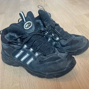 Adidas skor gore- tex - Ett par svarta adidas skor med gråa detailjer. Storlek 37 1/3, markerade som 37 då det är närmst. fint skick utöver lite smuts. Sulan är på skon rejält och är inte nära på att trilla av som många andra skor man köper secondhand. Supersnygga! ❤️