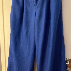 Byxor från Cos  - Vida byxor från Cos, hög midja. Strl 42, aldrig använda med prislapp. Köparen står för frakt