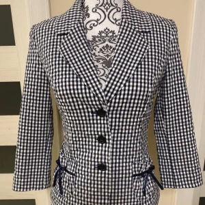 Kavaj - Marinblå och vitrutig kavaj med söta rosetter. 