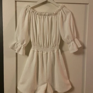 Vit Playsuit  - En vit playsuit i storlek S, ifrån Nelly och köpt för ca 2 år sen, använd en gång och inga fläckar alla, superfint skick 