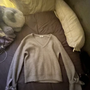 Super fin stickad tröja - Tröjan har rosetter vid händerna och är super mjuk