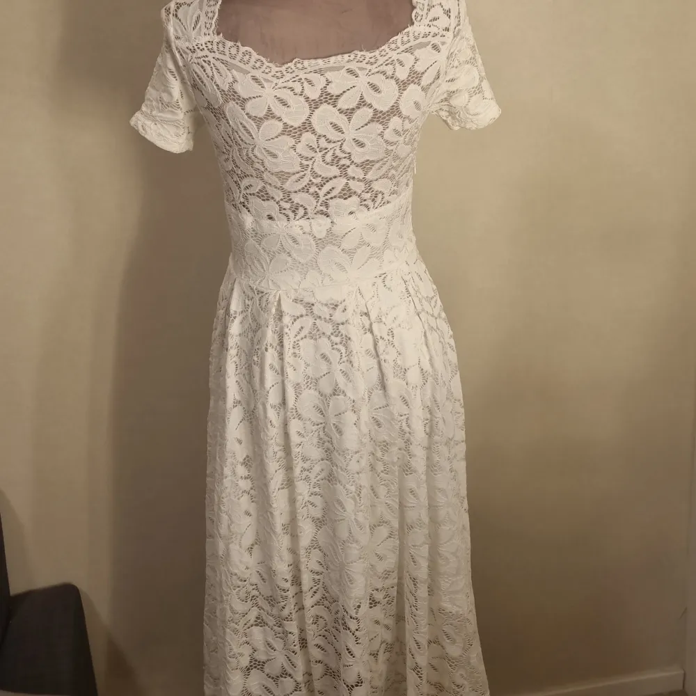 En vit klänning med spets mönster. Säljer för att den inte kommer till användning längre . Klänningar.