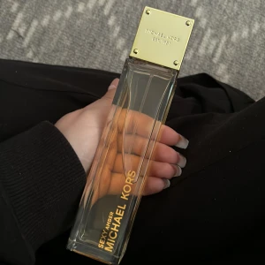 Michael Kors Sexy Amber, EdP - En sexig och sofistikerad doft som kombinerar mjuka toner av vita blommor med varmt sandelträ som kläs i en slöja av sensuell och söt ambra  Doftfamilj – Orientalisk/Blommig Doftnoter – Ambra, sandelträ och vita blommor