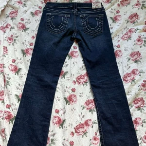Lågmidjade marinblå true religion bootcut jeans - Snyggaste marinblåa lågmidjade bootcut true religion jeansen! Knappt änvända och i bra skick👍  pris går att diskutera💞 innerbenslängden-85cm midjan-40cm totala längden-106cm  