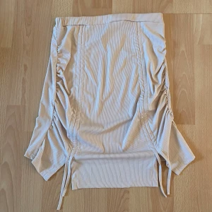 Kjol - Beige kjol som man kan justera längden på med snörena där framme, har aldrig använts då jag inte tyckte färgen passa på mig🌸