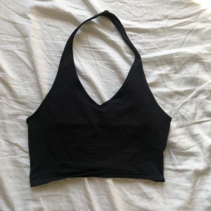 Svart top  - En svart top med band runt halsen. 