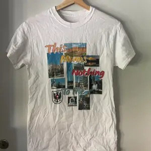 White tee with cool print and text reading 'This Means Nothing To Me'