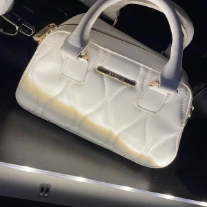 Bessie väska  - Säljer nu min bessie väska, då jag inte har haft användning för den. Köpt för 450kr i Paris. Använd 1 gång. Axelband kommer med väskan. Några desinfektioner är att det finns små solblekta fläckar på handtagen, dock är dem inget som syns.