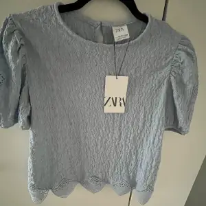 Ljusblå t-shirt med spets från Zaras barnavdelning. Aldrig använd och lappen är kvar. Storlek 164 men är som S