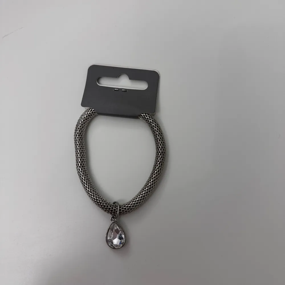 Ett grå/silvrigt armband från Ur&Penn med en fin sten!! Den är lite elastiskt så passar alla! Aldrig använd med lappen kvar!!. Accessoarer.