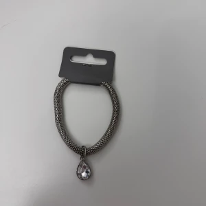 Armband - Ett grå/silvrigt armband från Ur&Penn med en fin sten!! Den är lite elastiskt så passar alla! Aldrig använd med lappen kvar!!