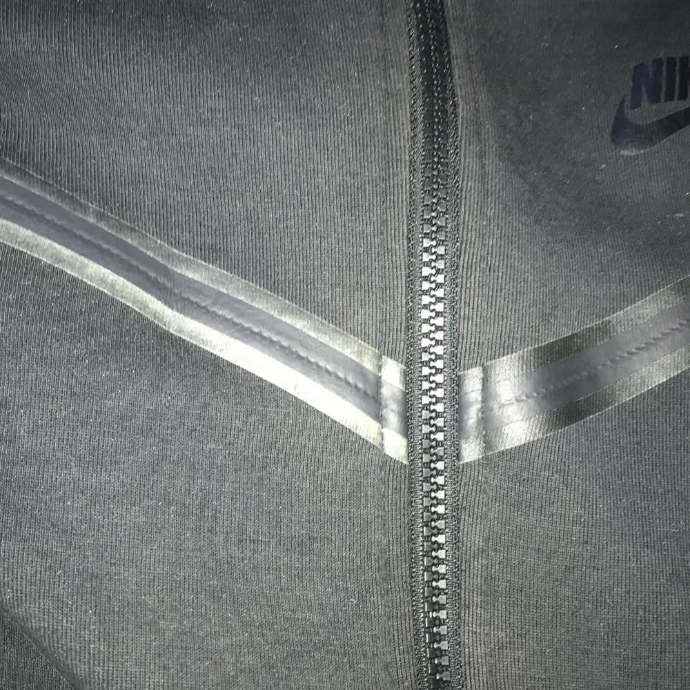 Säljer svart nike tech i storlek XL i barn. Har en liten missfärgning på vänstra sträcket annars är det bra skick. . Hoodies.