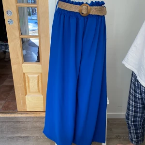 Vida byxor med bälte - Supersnygga byxor med vida ben, tunn material som får fin fall. Hel långa ben och hög i midjan. Stretchiga vid midjan så det passar M och L