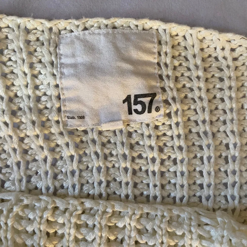 En vit hålstickad tröja ifrån lager 157, finns inte att köpa längre. Passar nog ändp ifrån L till S, beroende på hur man vill att den sitter. Stickat.