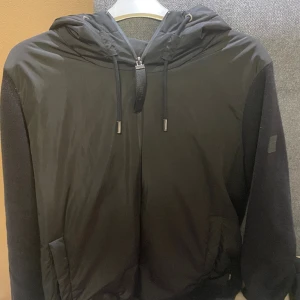 Hugo Boss Hybrid cardigan - Super skön och snygg Hugo boss Cardigan, använd 2 gånger så den är 10/10 skick, Nypris 4000kr, säljer pga intressekoll