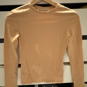 Acne tröja  - Så cool acne tröja i beige färg. Inte genomskinlig alls. Använd en gång. Har en liten fläck fram som man ser på tredje bilden. Dock syns denna knappt
