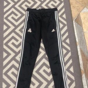 Adidas träningsbyxor  - Säljer adidas träningsbyxor för att dem är för små. Sitter korta på mig som är 157. Defekter: adidas märket håller sakta på att gå bort och jag har klippt av tråden som man kunde töja i midjan. Passar folk som är runt 148-153 cm. Skriv on bilder osv💕