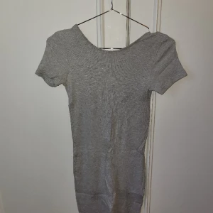 Grå ribbad klänning med öppen rygg - Grå ribbad tröja med öppen rygg.