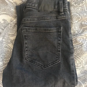 Weekday jeans - Mörkgrå/svarta jeans från weekday modell TWIG, storlek 24/32 men dock uppsydda, för mig som är cirka 162cm.