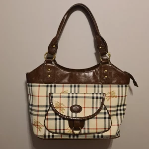Väska - Fin väska med burberry logo. Ej äkta produkt. I gott skick. Rymlig och får plats med dator. 