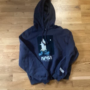 nasa hoodie  - rätt mörk grå men lite blått i oxå. en färgad hoodie med tryck på. tveka inte om ni vill ha fler bilder eller undrar över något