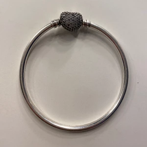 Pandora armband💋 - Silvrigt Pandora armband med ett glittrande hjärta🪩 köptes utomlands. Den är lite sne men det syns inte när man har den på sig❤️ pris är diskuterbart. Det är bara att säga till för fler bilder👌