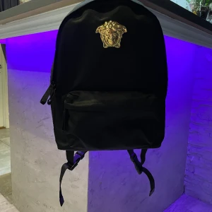 VERSACE MEDUSA LOGO PLAGUE BACKPACK BLACK - Hej! Säljer varan nu för den inte kommer till användning jätte bra skick, Inte använd så många gånger, sista bilden så ser ni att varan är äkta!! Kan även tänka mig att byta mot något.