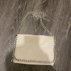 Vit Tiamo väska  - Säljer min vita Tiamo väska då den inte har kommit till så mycket användning💕 Den är i väldigt bra skick och har inga skador förutom en liten som vissas på en av bilderna 💕Är i mellan storlek en💕Pris kan diskuteras💕