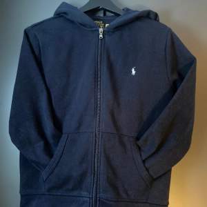 Säljer en marinblå Ralph Lauren fleece full-zip Hoodie i storlek 14-16/(160). Säljes pga för liten! Använd fåtal gånger! Nypris 1095kr mitt pris 399kr