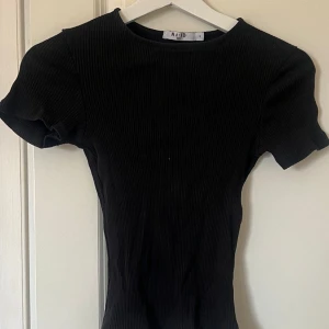 Ribbad t shirt  - Ribbad t shirt från nakd med en snygg öppning i ryggen!🖤 aldrig använd 