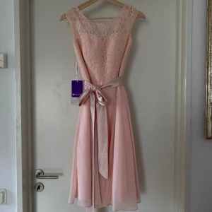 Klänning  - Helt oanvänd, fin rosa färg och passar till många sorters tillfällen. Storleken anser jag vara större än vad de talar om på tagen. Mer en 34/36 än en 32a.