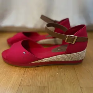 Röda Tommy Hilfiger sandaler i modellen Rope Wedge med guld detaljer. Skorna är oanvända. 