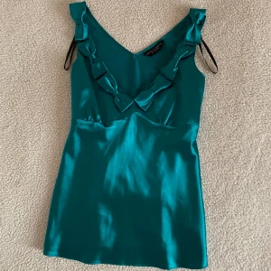 Dorothy Perkins vintage turkost linne med rosetter - Otroligt vackert linne med rosetter från märket Dorothy Perkins. I utmärkt skick, utan anmärkningar. Mycket bekvämt, storlek 34 men passar även 36. Använt i några timmar endast.